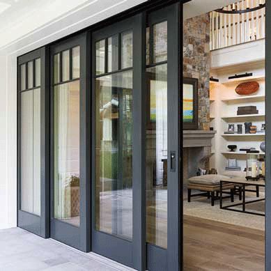 A sliding glass door opens to a patio area, showcasing a large glass window design by the smart window solution industry.