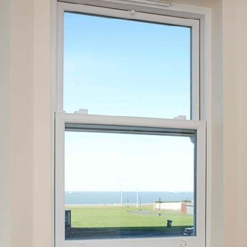 A vertical slider window in Lucknow by Smart Window Solution Industry, showcasing a breathtaking ocean view and a serene beach.