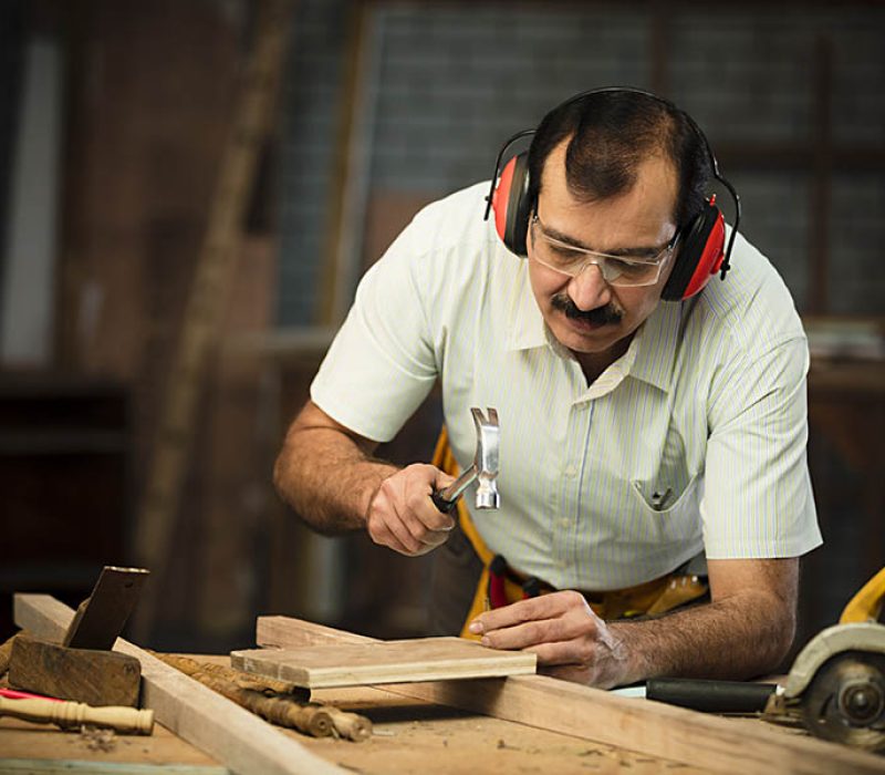 A man crafting wood for smart window solution industry, designing a window and door.